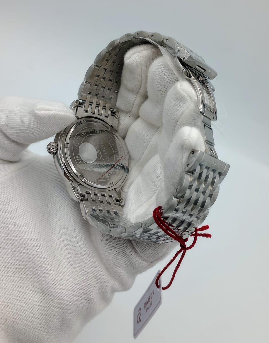 Stainless steel men's wristwatch with metal strap, shown from back, held by gloved hand