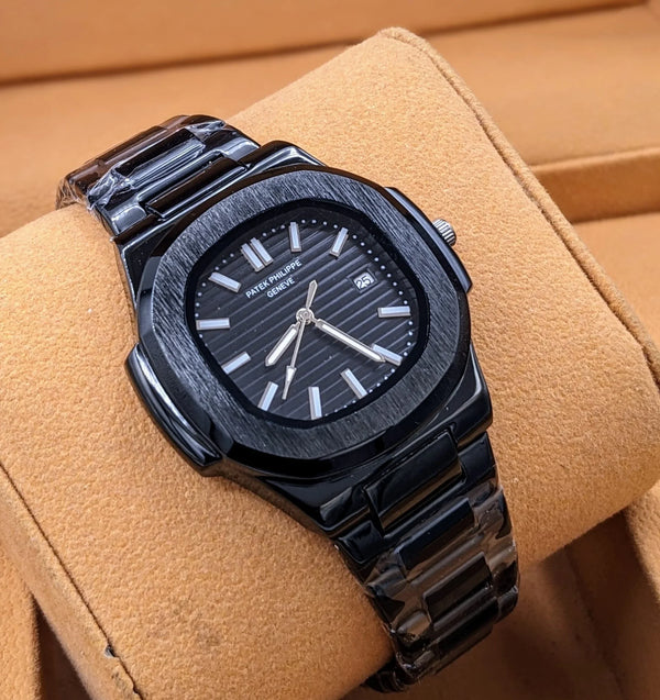 Men’s black luxury wristwatch with metal band and date display on a beige cushion.